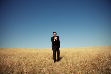 Businessman shouting at the megaphone to you