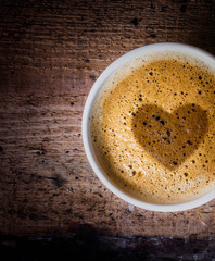 Closeup cup of espresso on old wooden table over grunge backgrou