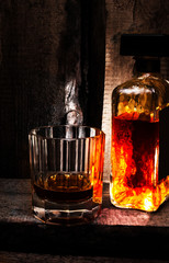Glass of Whiskey Scotch and a bottle on old wooden background. O