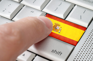 Business concept male finger pressing Spain enter key