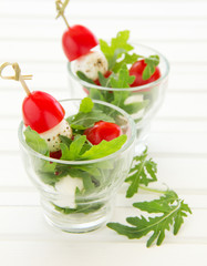 Salad with arugula, mozzarella and tomatoes.