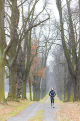 Obraz premium woman wearing rubber boots in autumnal alley