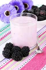 Sweet blackberries with yogurt on table close-up