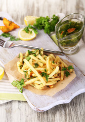 French fries on tracing paper on board on napkin wooden table