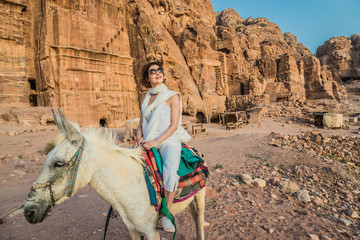 tourist riding donkey  in nabatean city of  petra jordan - obrazy, fototapety, plakaty