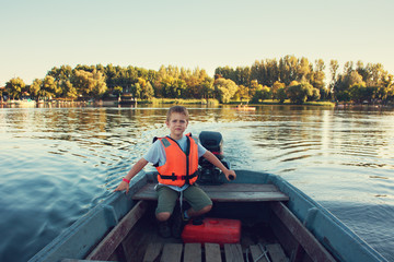Little boy driving a boat
