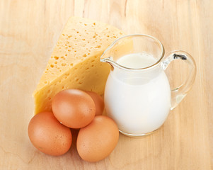 Big piece of cheese, glass jug with milk
