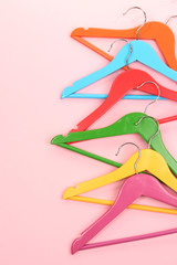 Colorful clothes hangers on pink background