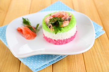 Colored rice on plate on napkin on wooden table
