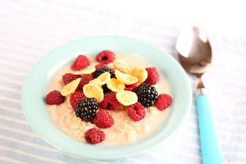 Oatmeal in bowl with berries isolated on white