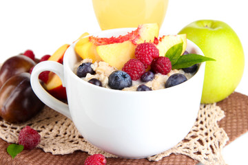 Oatmeal in cup with berries on napkins isolated on white