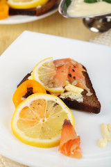 Salmon sandwiches on plate  on wooden table close-up