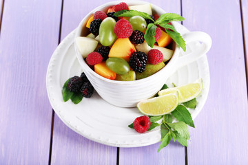 Fruit salad in cup on wooden table
