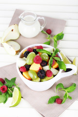 Fruit salad in cup on wooden table
