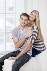 Fototapeta premium happy young caucasian couple sitting on couch