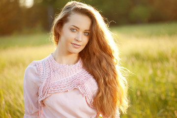 Smiling woman  in a field at sunset