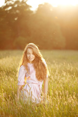 Fototapeta na wymiar Smiling woman in a field at sunset