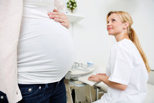 Pregnant Woman With Doctor Preparing For Ultrasound Scan