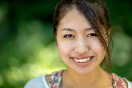 Asian woman smiling happy face in a park bench