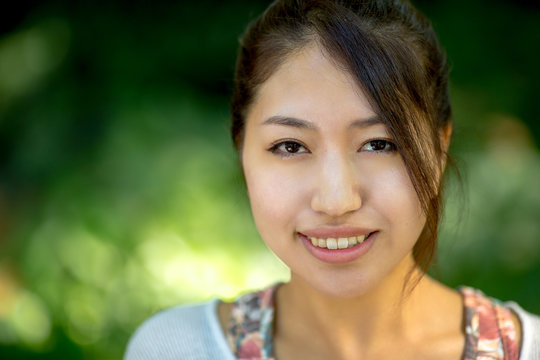 Asian woman smiling happy face in a park bench