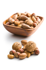 various unpeeled nuts in wooden bowl