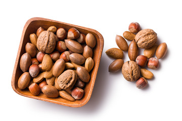 various unpeeled nuts in wooden bowl