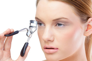 Attractive blonde model using eyelash curler