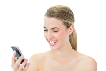 Happy attractive blonde reading a message on her smartphone