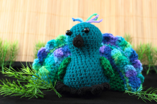handcrafted toy peacock crocheted from blue and green yarn