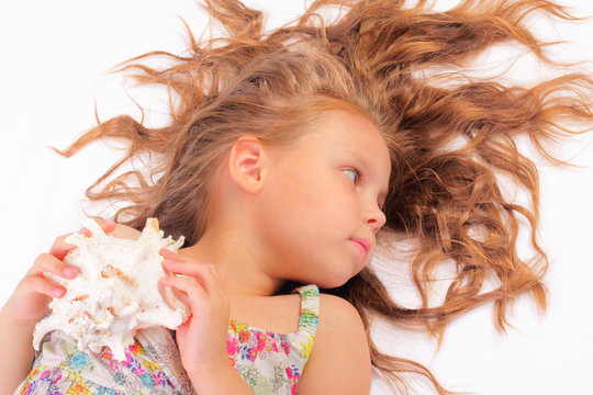 Calm little girl with seashell