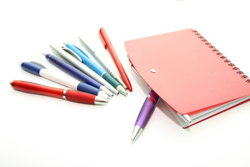 Set of office pens and red notebook