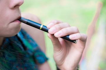 Woman smoking electronic cigarette outdoor