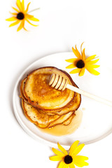 A stack of pancakes with honey