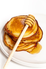 A stack of pancakes with honey