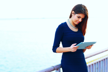Smiling businesswoman using electronic tablet outside