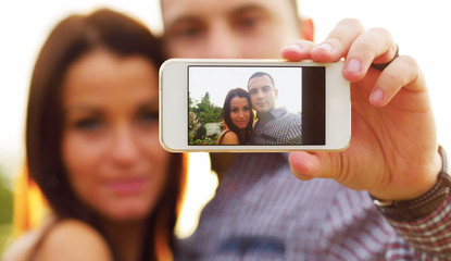 Couple taking self-portrait photos with mobile smart phone