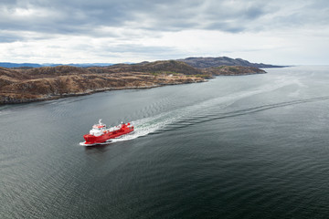 Small Norwegian red oil products tanker ship in the fjord