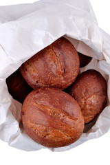 Fresh and delicious bread in a paper bag on a white background