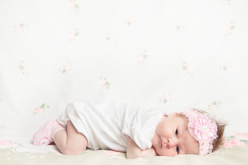 Beautiful newborn girl holding a flower - 56075675