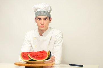 Portrait of a beautiful chef and a slice of a green melon