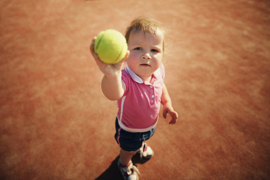 little funny girl with tennis ball