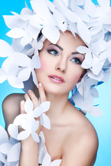 Wonderful girl in a hat from paper white butterflies. On a blue 