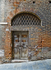 Antiqu door in Siena street. Siena, Italy
