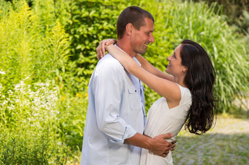 Obraz premium Playful Caucasian couple embracing outdoors