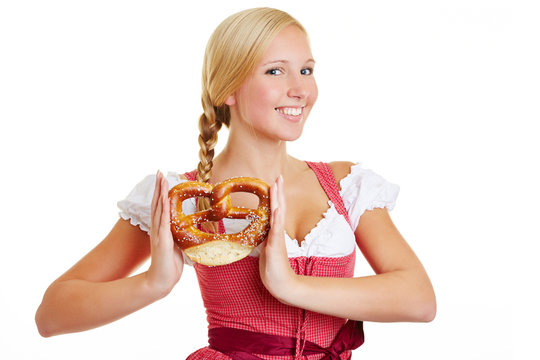 Happy woman in dirndl with pretzel