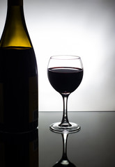glass and a bottle of red wine