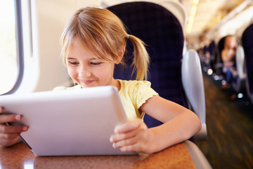 Girl Using Digital Tablet On Train © Monkey Business