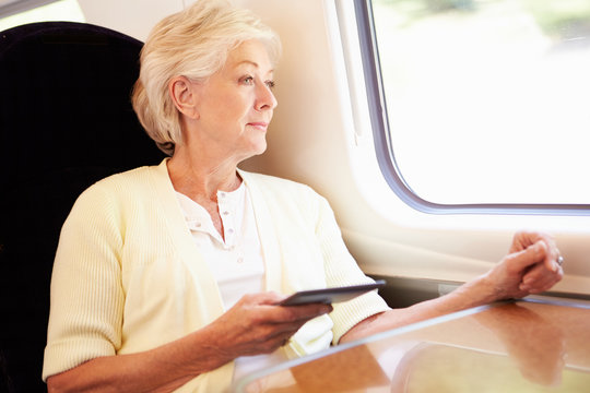Senior Woman Reading E Book On Train Journey
