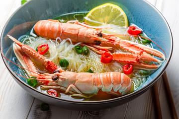 Closeup of Thai soup with scampi and noodles