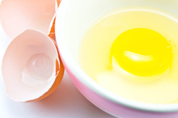 Raw egg in a cup on a white background